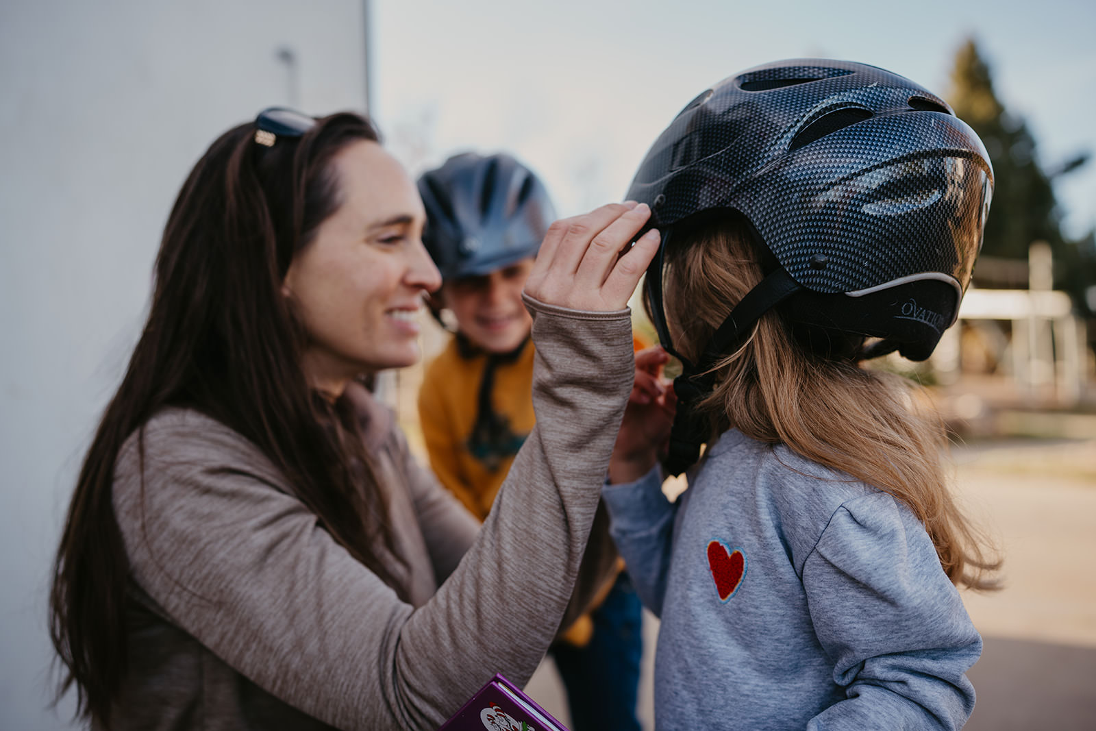 equine therapy branding photos of woman putting helmet on kids.