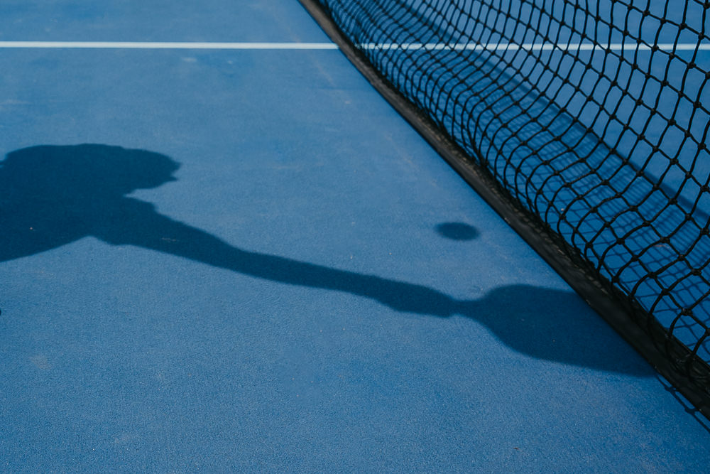 Brand photo of shadow of playing pickleball.