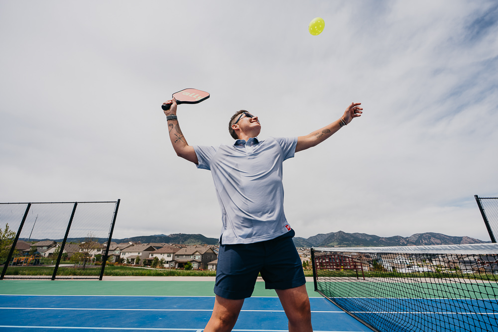 Brand photo of queer woman playing pickleball.