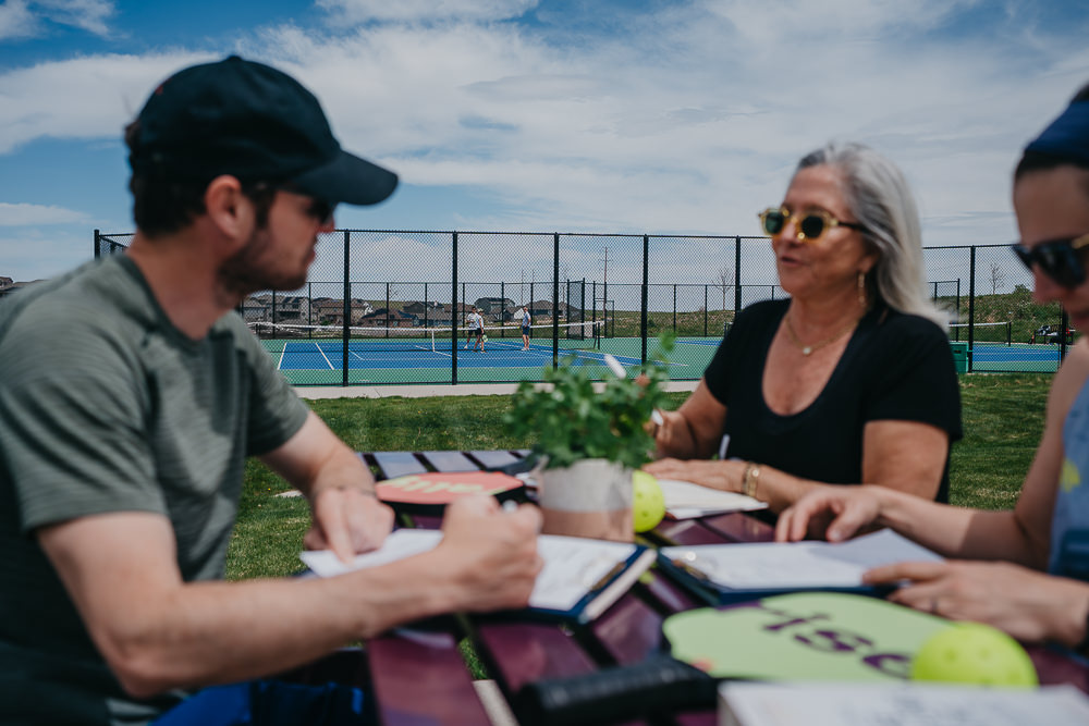 Brand photo of group working at pickleball court.