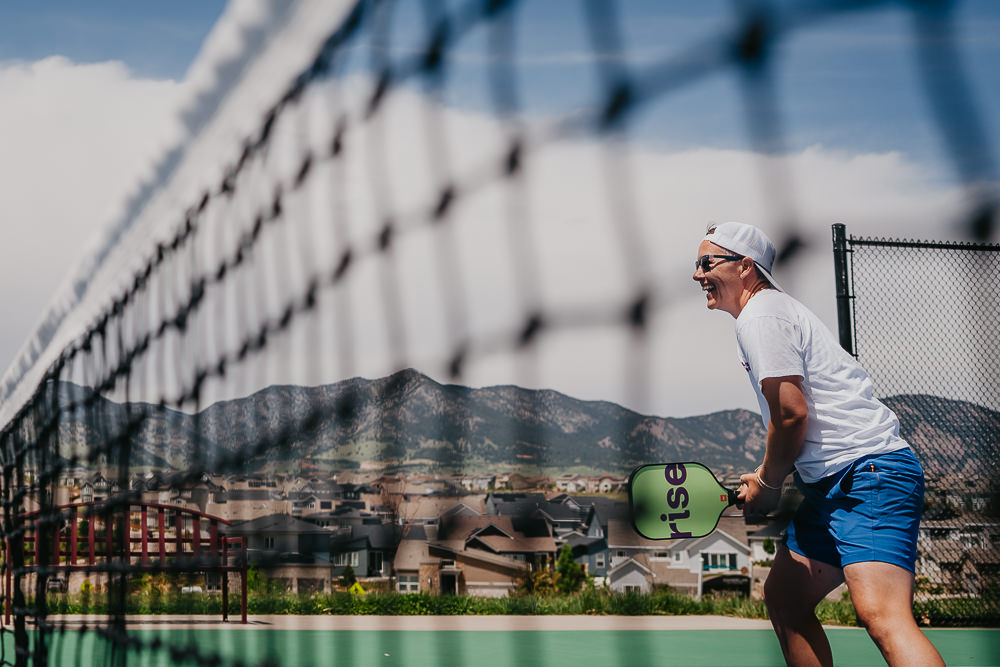 Brand photo coach playing on pickleball court.
