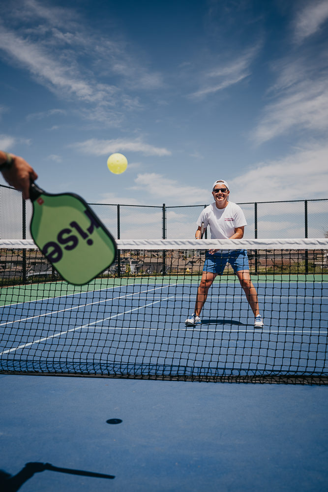 Brand photo coach playing on pickleball court.