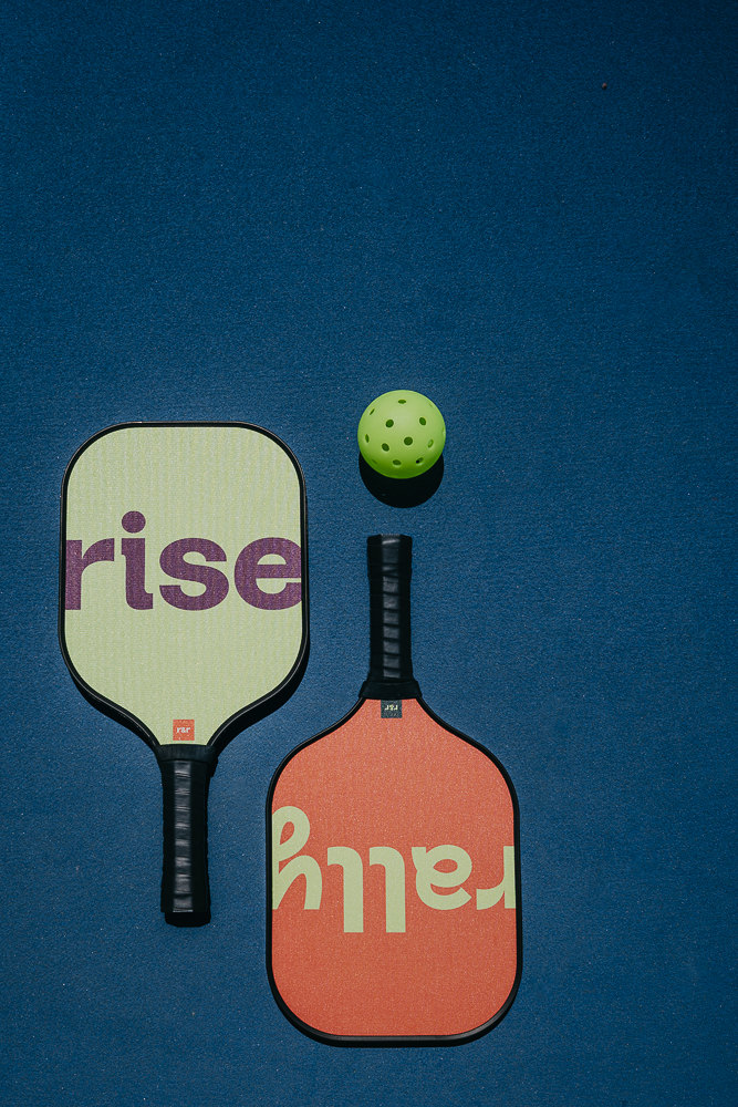 Brand photo of rise & rally pickleball paddles on court.